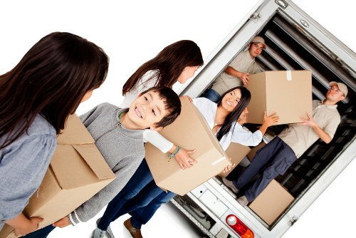 Moving boxes and furniture being unloaded at a Kennington property
