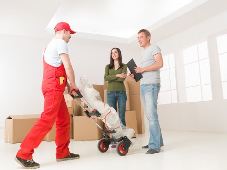 Removal crew handling office items in a tight Kennington access area